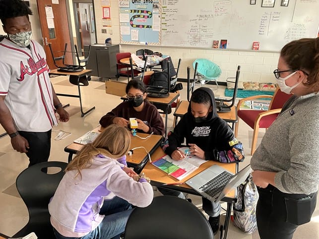 Students and coaches in a Robotics League session. 
